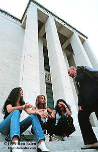 A balding, smartly dressed italian man attempts in vain to chat up / pick up three attractive female students at the La Sapienza University in Rome, Italy