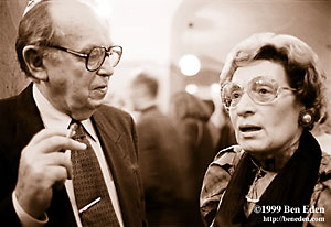 An older Jewish couple wearing glasses, the man smokina a cigarette, at a Chanukah (Hanukah) celebration held in Prague, Czech Republic Jewish Community's eating hall.