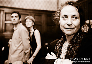 Middle-aged Prague Jewish woman smiles in anticipation while a young couple watches in background on the dance floor at a Chanukah (Hanukah) party in the Community.