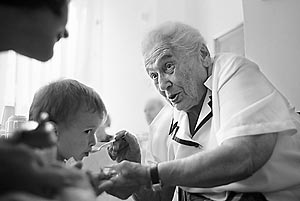 Elsa Ehrlichova, a Czech Holocaust survivor, spoon feeds one of her nephews during his visit to the Charles Jordan retirement home in Prague, Czech Republic.
