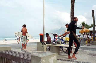 A surfer in a neoprene wetsuit on Ipanema beach, Rio de Janeiro, Brazil