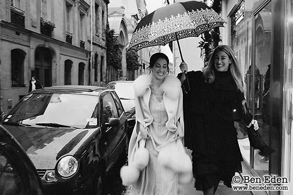 Bride with Bridesmaid under umbrella in rain in Paris, France