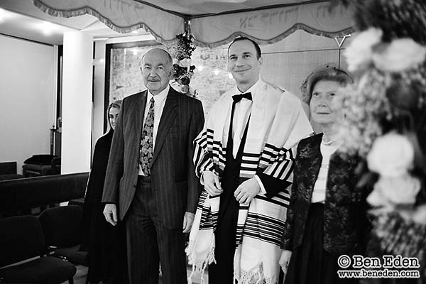 Groom standing under the Chuppah with his parents