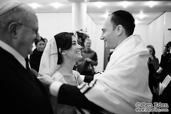 Jewish groom lifts his bride's veil